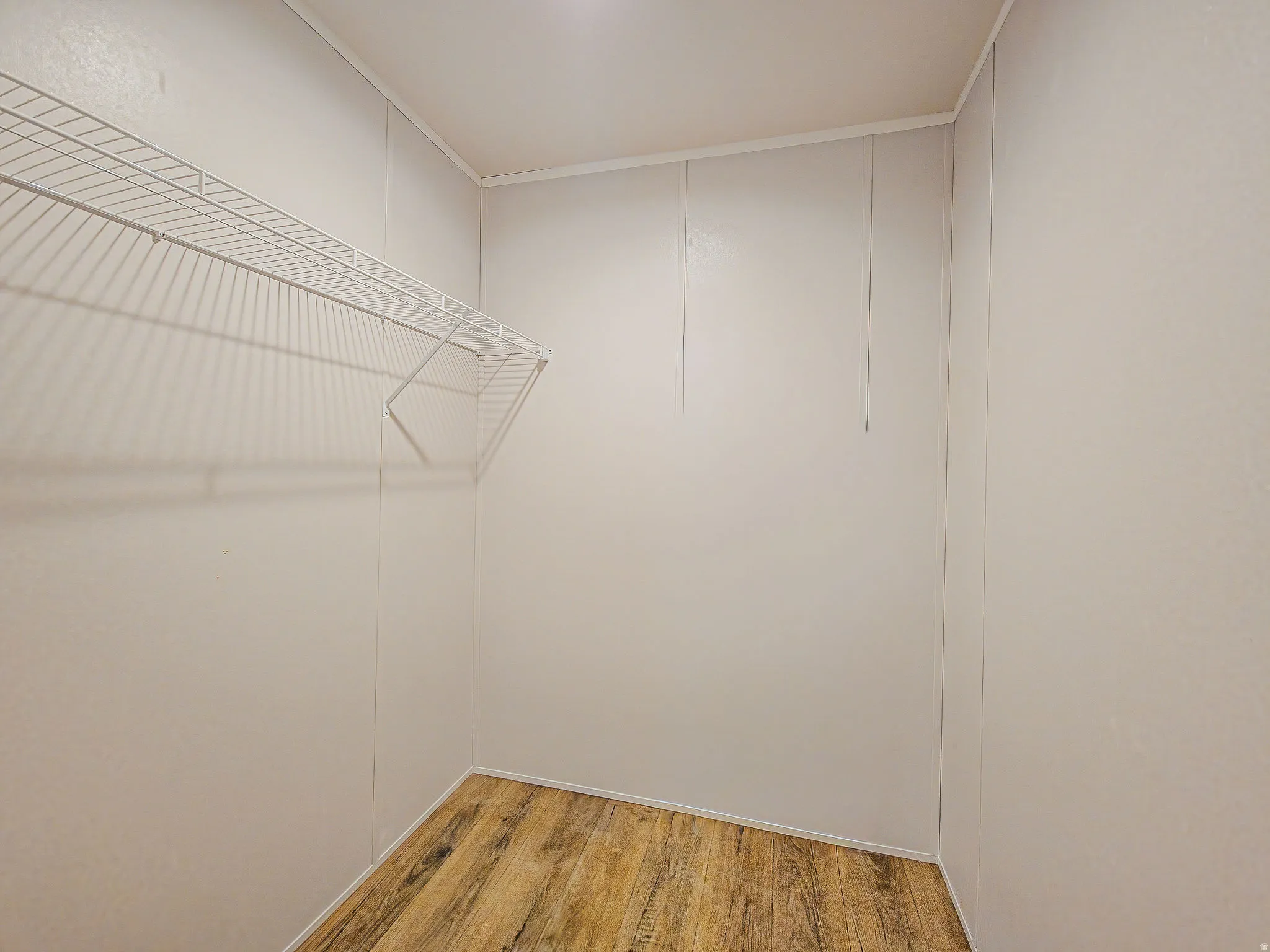 Wire shelving system, light-colored walls, wood-finish flooring, and white trim