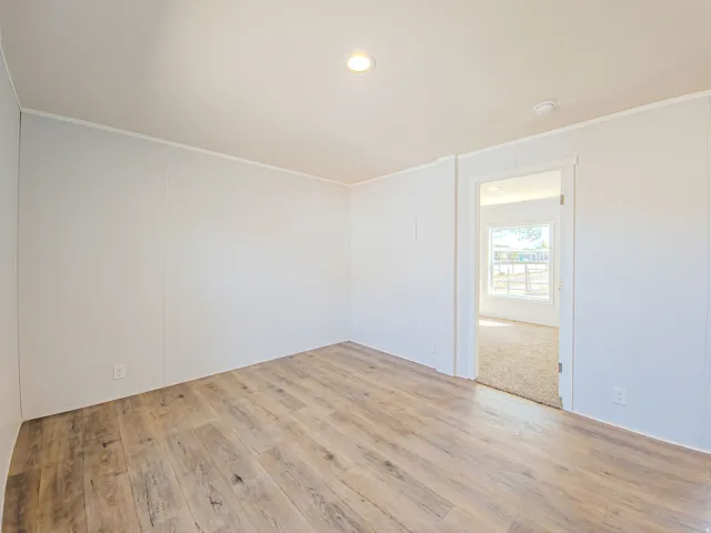 Recessed lighting, wood-finish flooring, and a neutral color palette