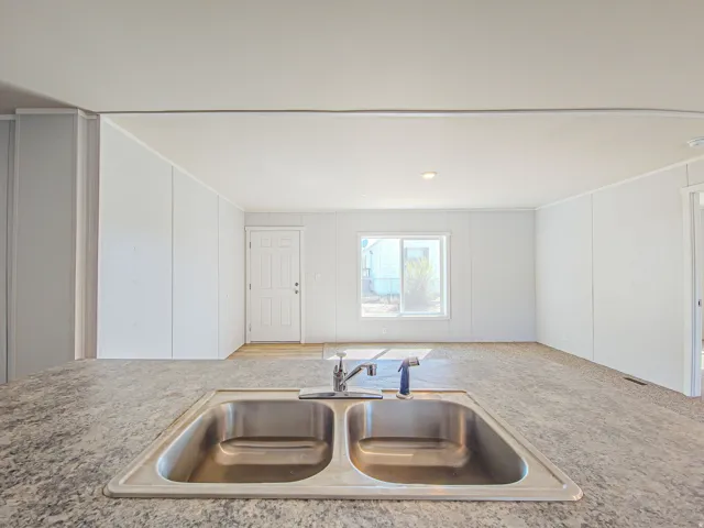 Stainless steel double basin sink with a single-handle faucet, set within a speckled countertop