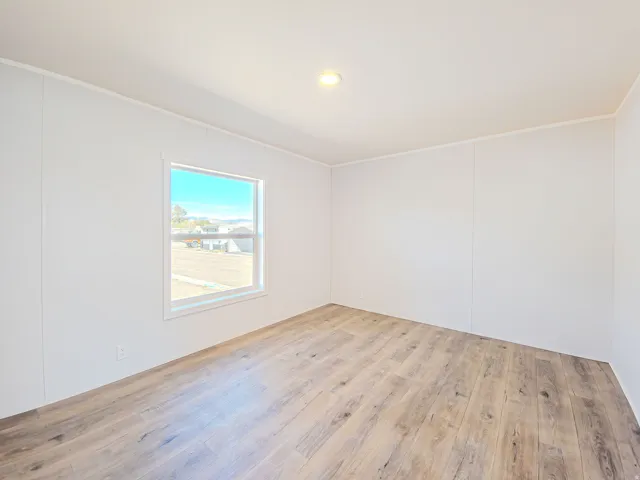 Wood-finish flooring, recessed ceiling light, white trim, and a window with a white frame