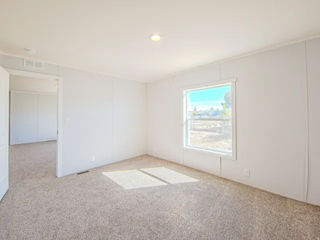 Neutral wall finishes, recessed ceiling lighting, and plush carpet flooring