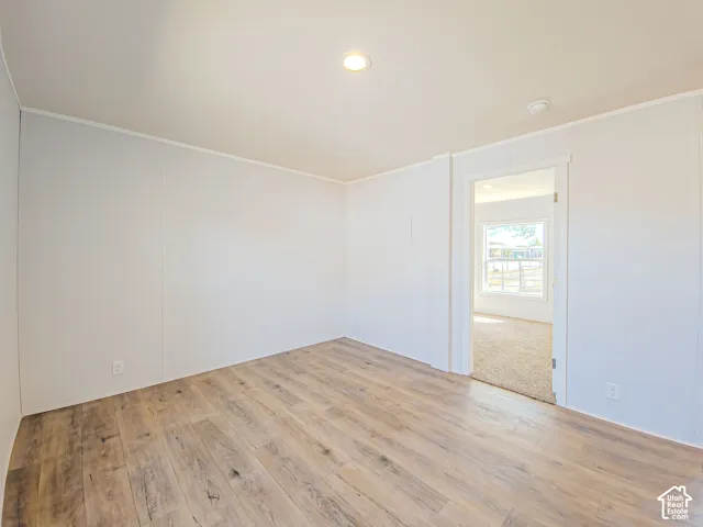 Recessed lighting, wood-finish flooring, and a neutral color palette