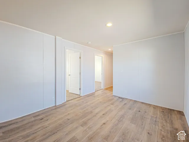 Wood-finish flooring, recessed ceiling lighting, and white paneled walls