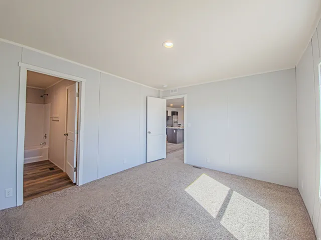 Recessed ceiling lighting, panel walls, carpet flooring, a full bathroom with a tub/shower combination, and wood-finish flooring