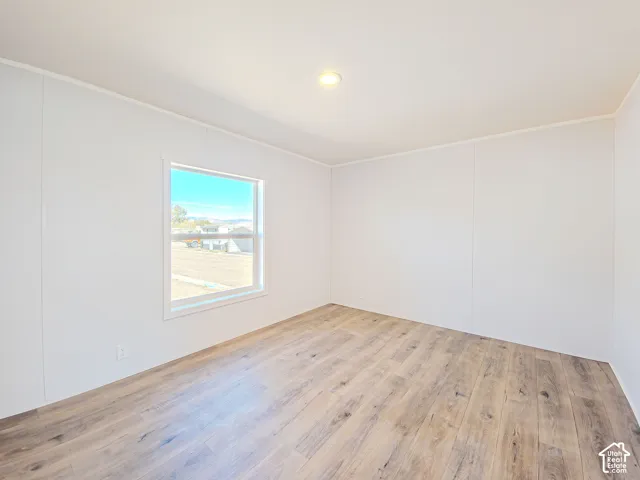 Wood-finish flooring, recessed ceiling light, white trim, and a window with a white frame