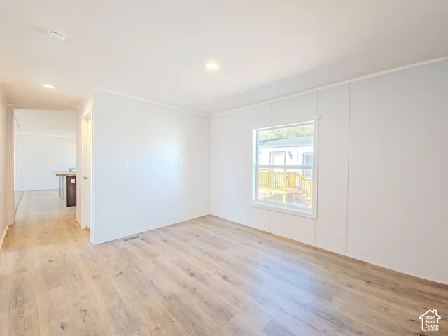 Recessed lighting, wood-finish flooring, and white paneled walls