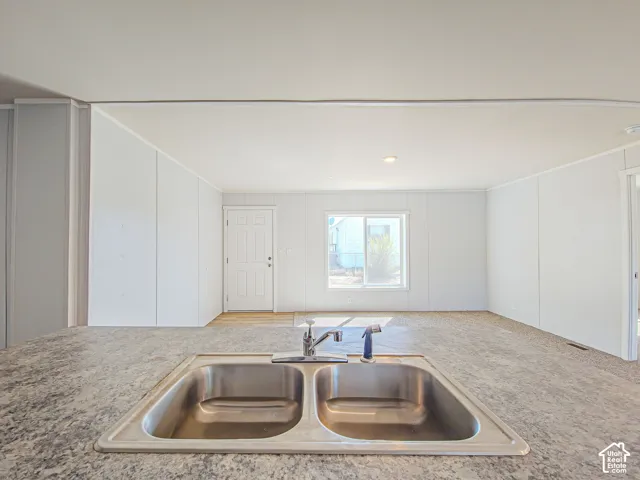Stainless steel double basin sink with a single-handle faucet, set within a speckled countertop
