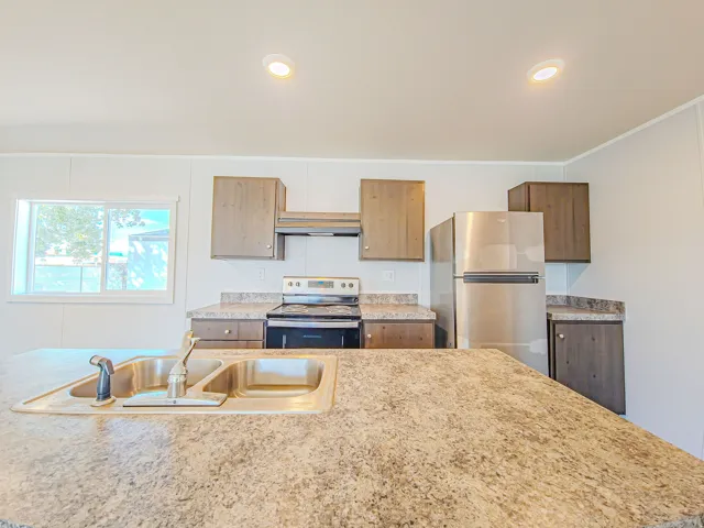 Kitchen featuring a dual-basin sink, built-in stainless steel appliances, upper and lower cabinetry, and recessed lighting