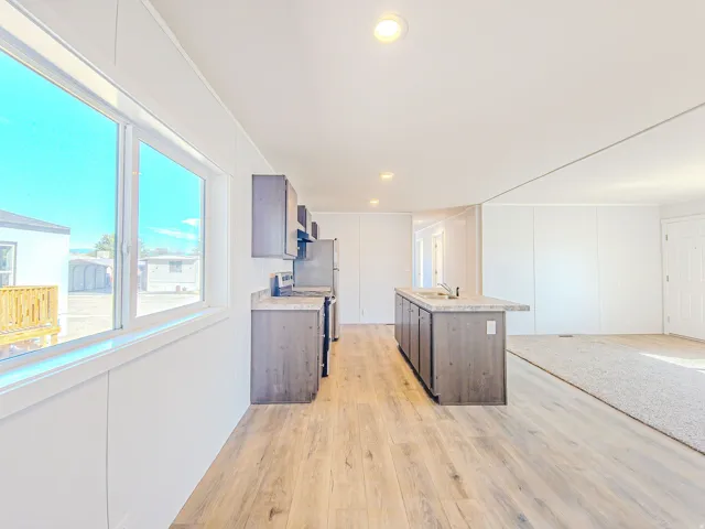 Open concept living area with wood-finish flooring, recessed lighting, and a kitchen island with seating