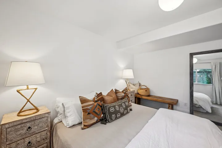 Bright bedroom with white walls and a ceiling light fixture