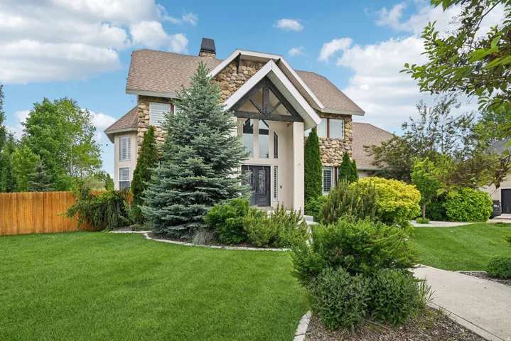 Stone and stucco exterior featuring an arched entryway with decorative wood detailing