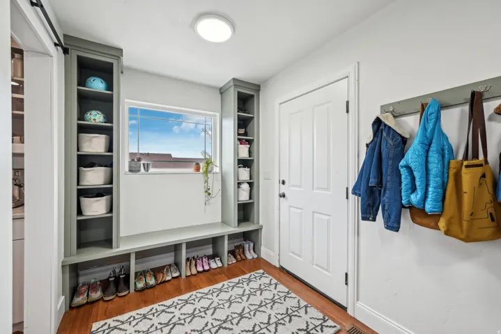 Entryway featuring built-in shelving, a window with natural light, wood-finish flooring, and a sliding barn door