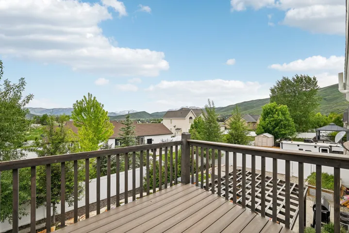 Expansive outdoor deck featuring wood-finish flooring and a dark wood railing