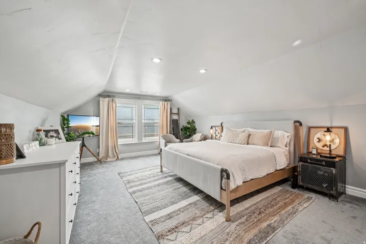 Attic room featuring sloped ceilings, recessed lighting, and soft gray carpeting