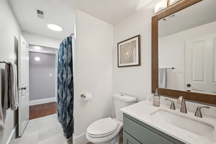 Full bathroom featuring a single vanity with a light gray cabinet, a white countertop, and a rectangular undermount sink