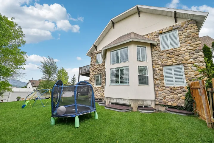 Expansive green lawn bordering a stone and stucco exterior