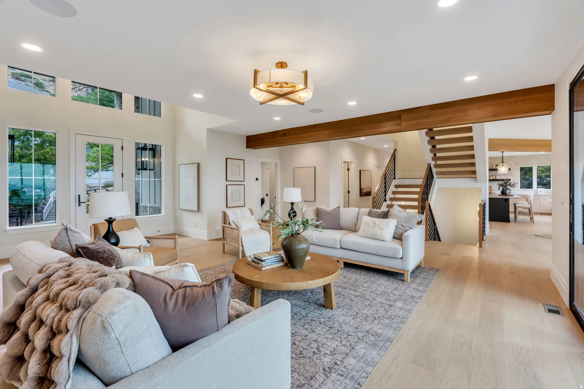 Open-concept living area featuring light wood-finish flooring, recessed lighting, and a contemporary ceiling fixture