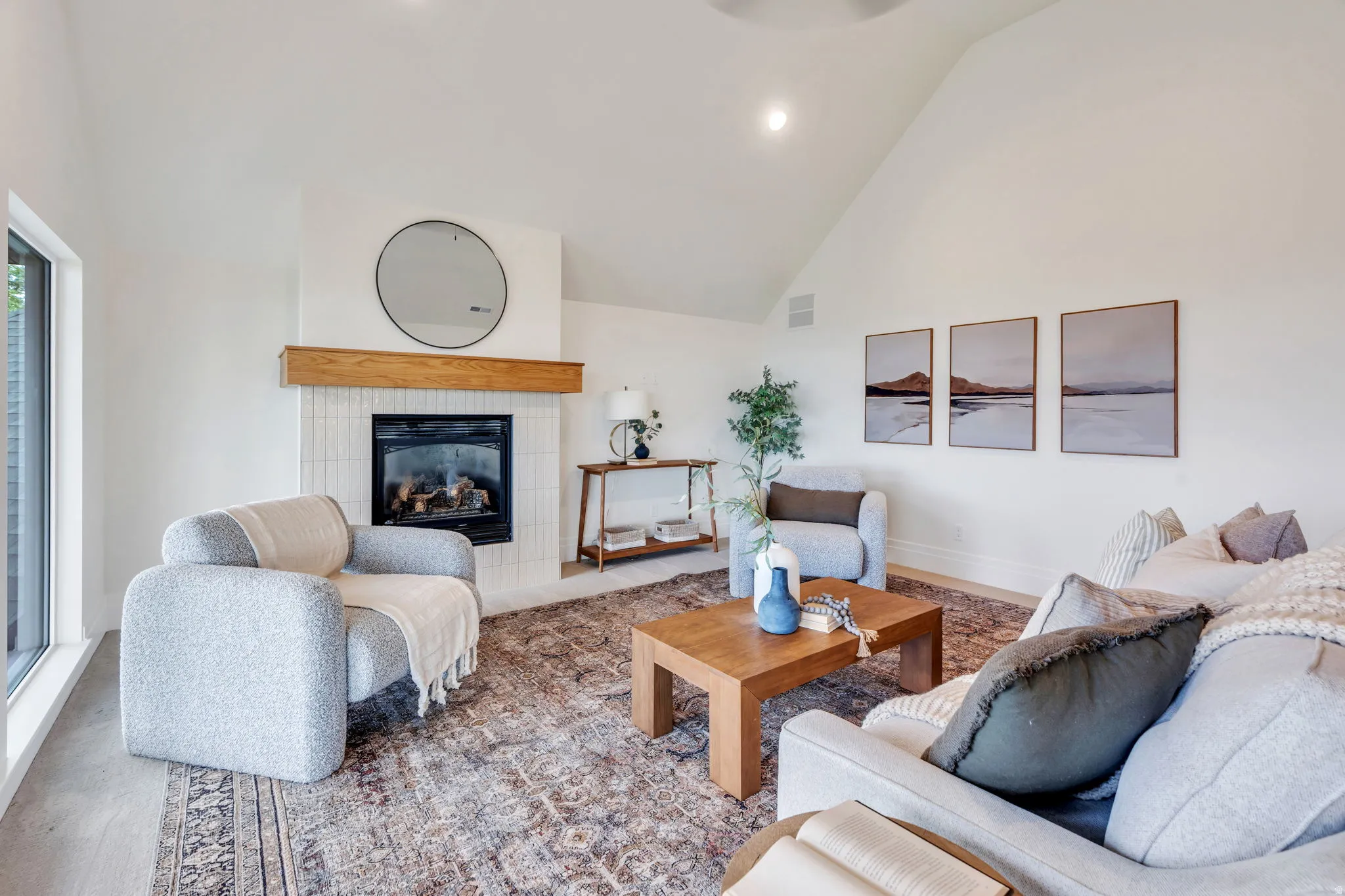 Living area featuring a vaulted ceiling and light wood-finish flooring
