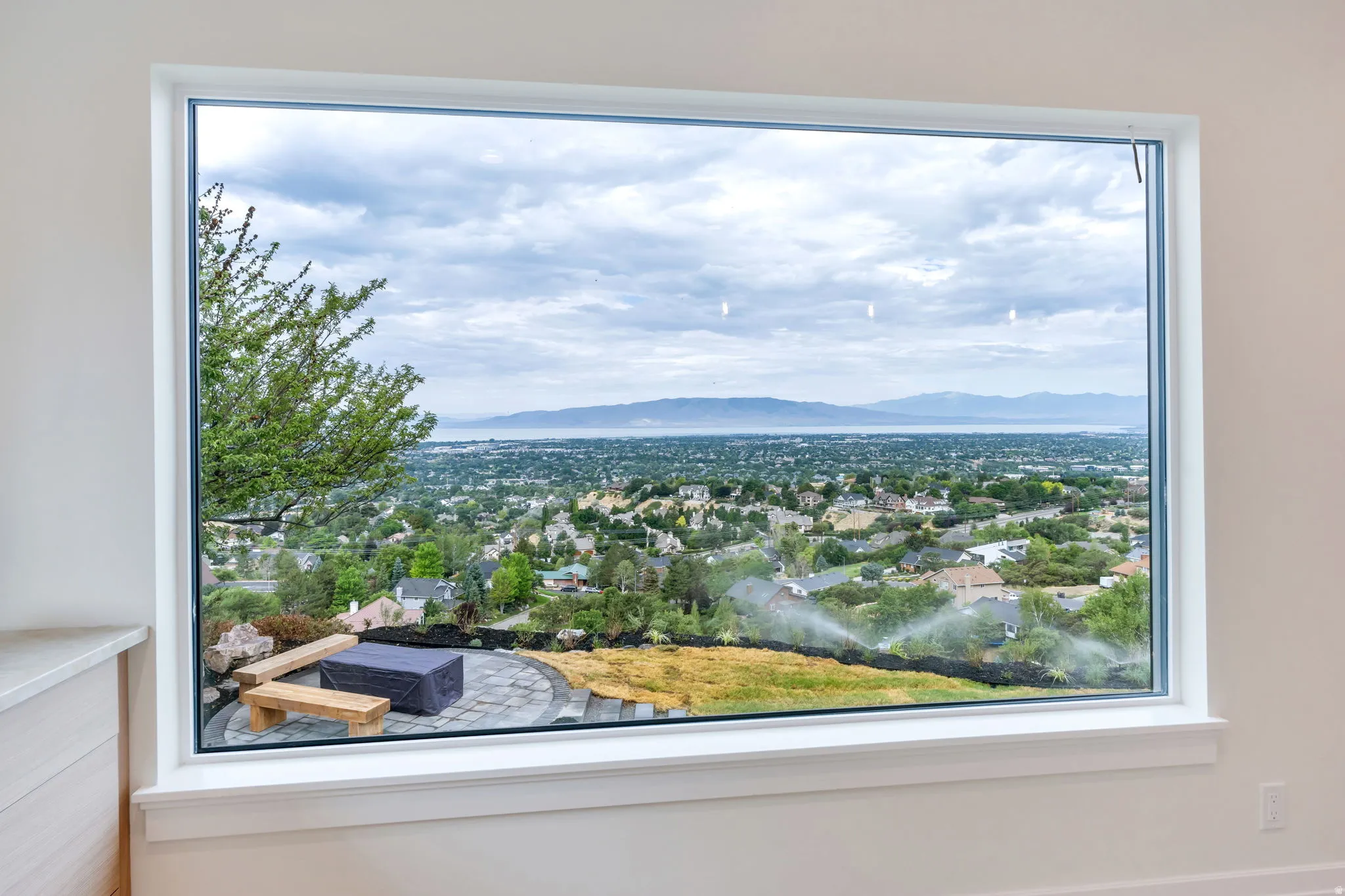 Expansive picture window framing a city and mountain landscape