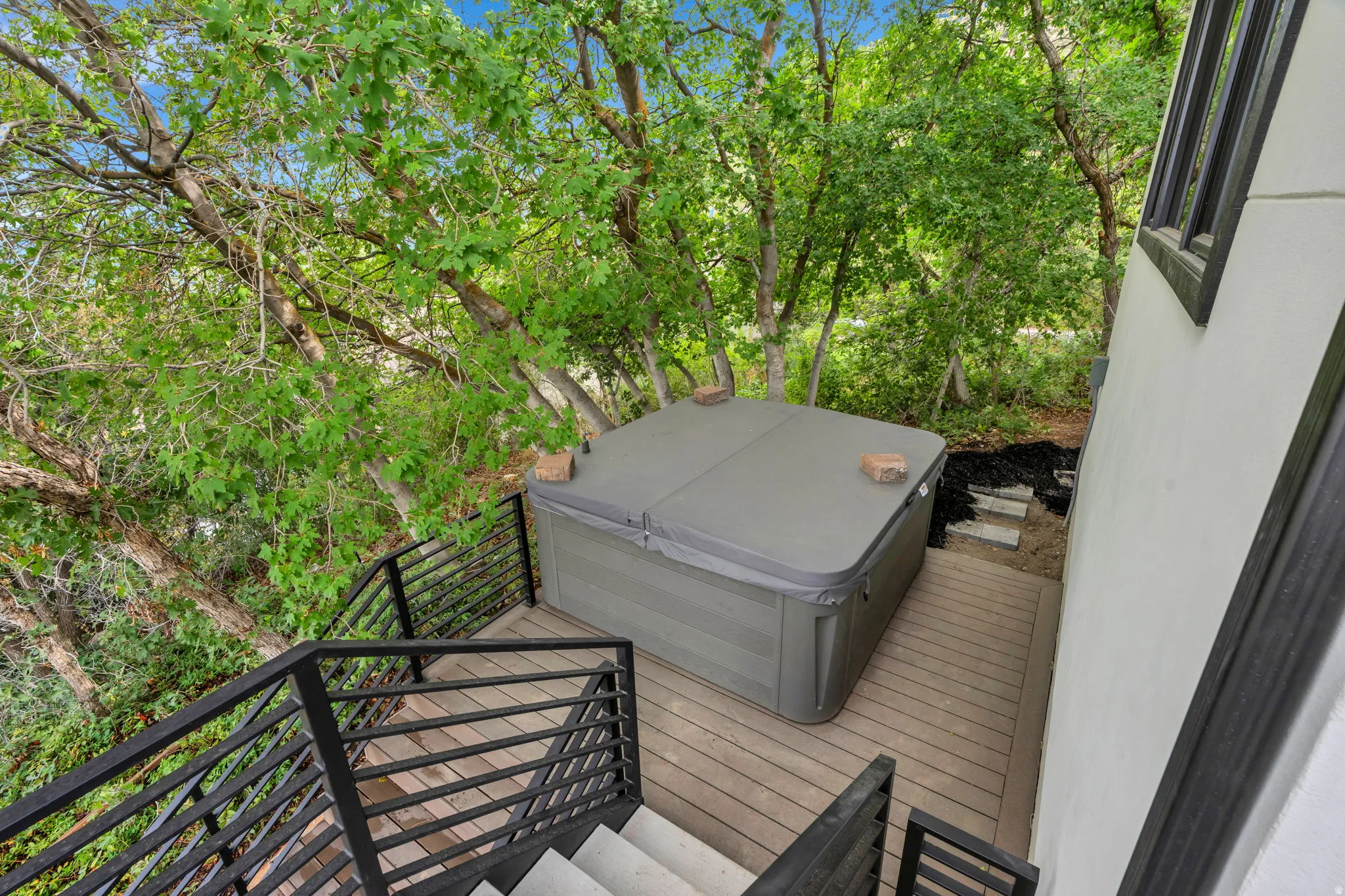 Outdoor deck with a built-in spa, composite decking, and black metal railings