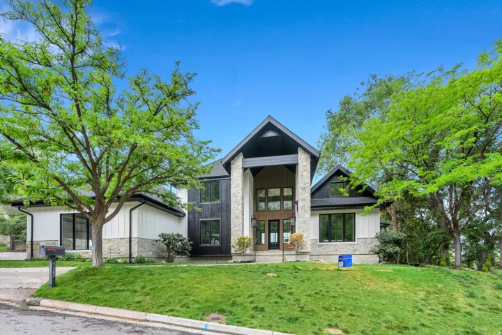 Modern architectural design featuring a prominent stone and dark wood-paneled facade