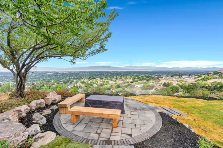 Circular paver patio featuring built-in wooden benches and a central fire pit area