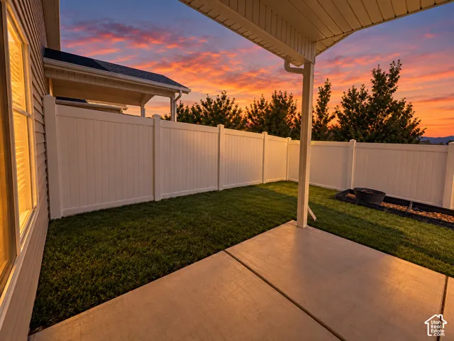 Private fenced yard featuring a concrete patio and a covered outdoor area