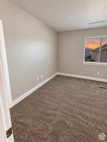Neutral wall paint, brown carpeting, white trim, and a window with horizontal blinds