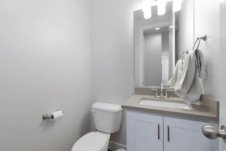Bathroom featuring a white vanity with cabinet storage, a light-toned countertop, and an undermount sink
