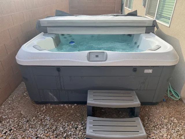 Spa with bubbling water, accompanied by a two-step entry, set on a gravel base