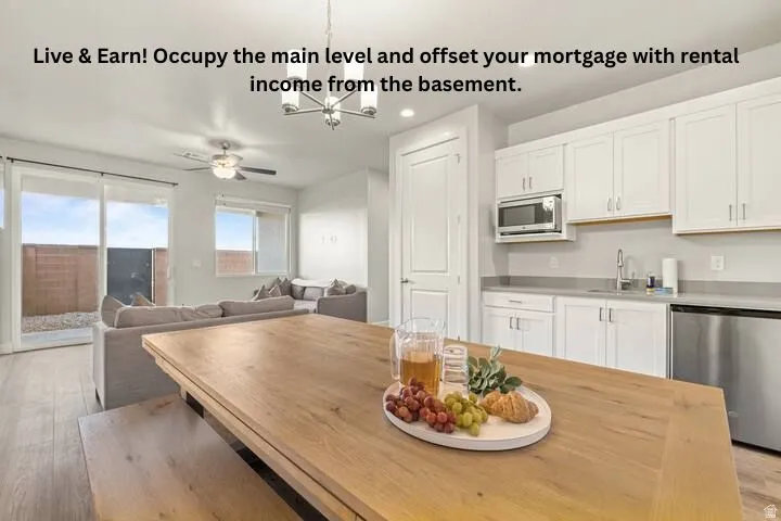 Open-concept living area featuring wood-finish flooring, a contemporary chandelier, and a ceiling fan