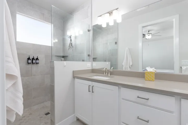Contemporary bathroom featuring a spacious glass-enclosed shower with light-toned tiled walls and a horizontal window