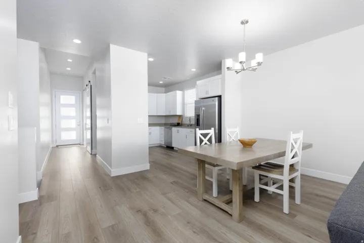 Open-concept living area featuring wood-finish flooring, recessed lighting, and a modern chandelier