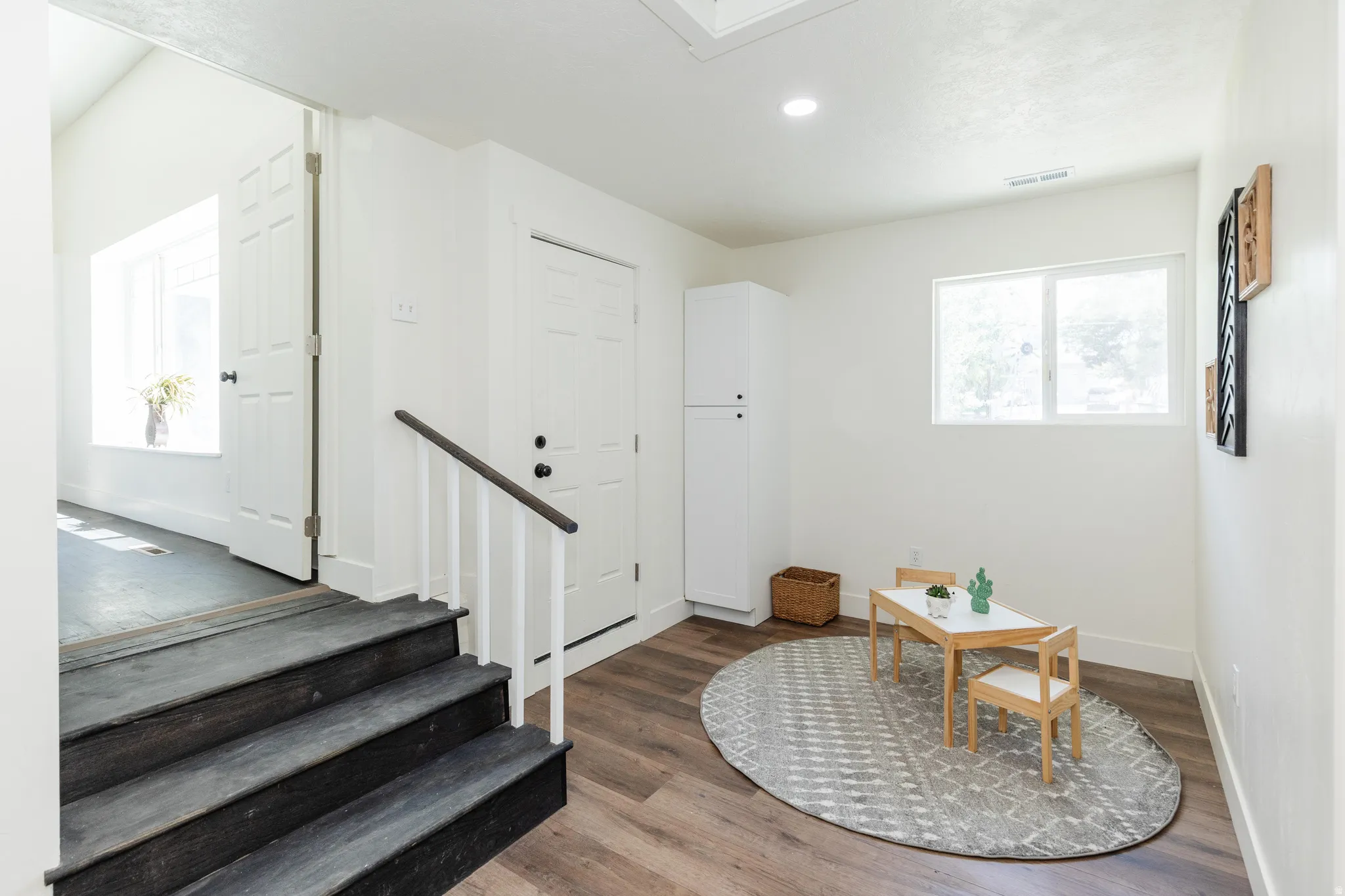 Entryway featuring wood-finish flooring, white walls, and a multi-pane window