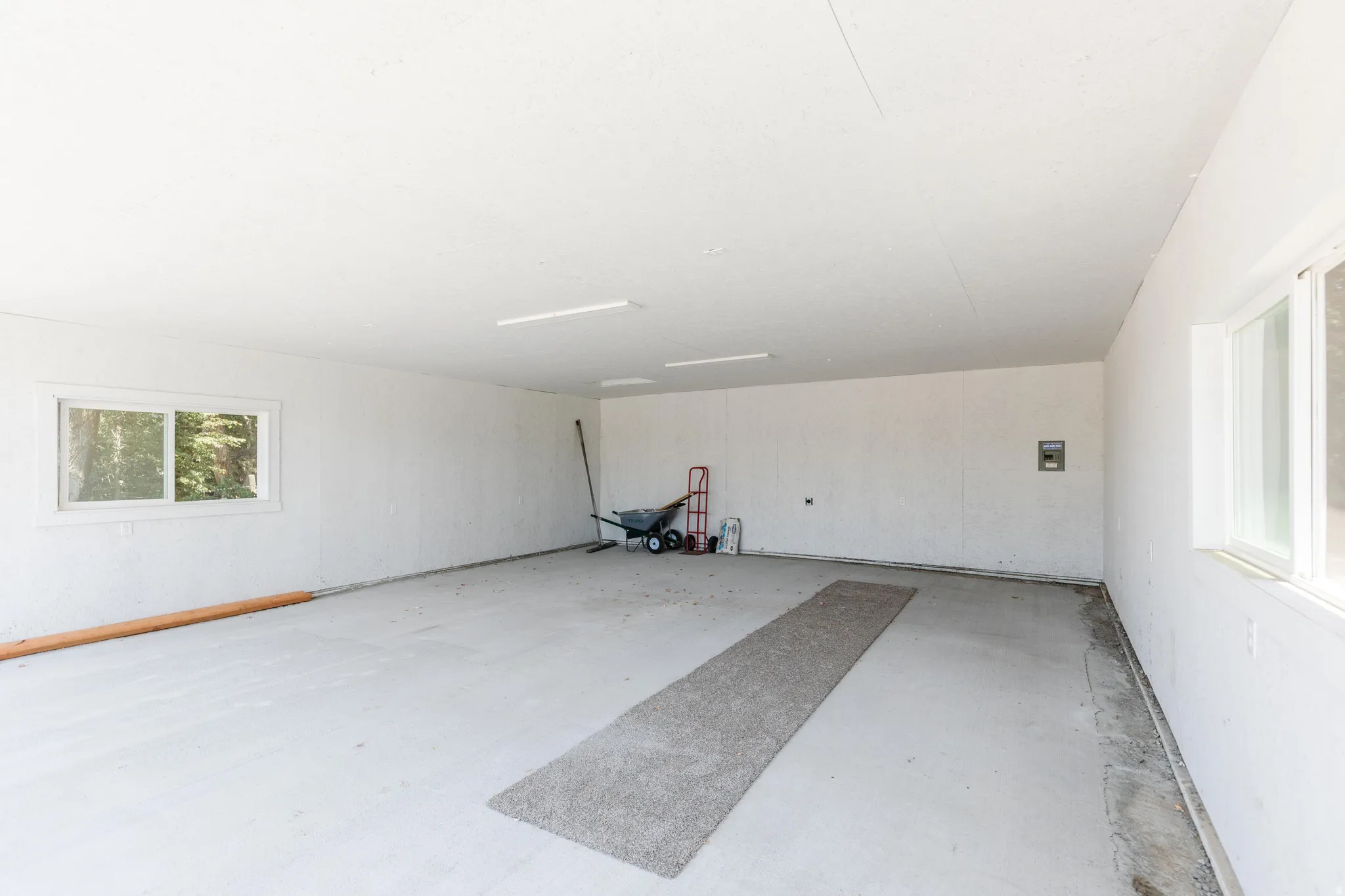 Spacious garage with multiple windows for natural light and painted concrete flooring
