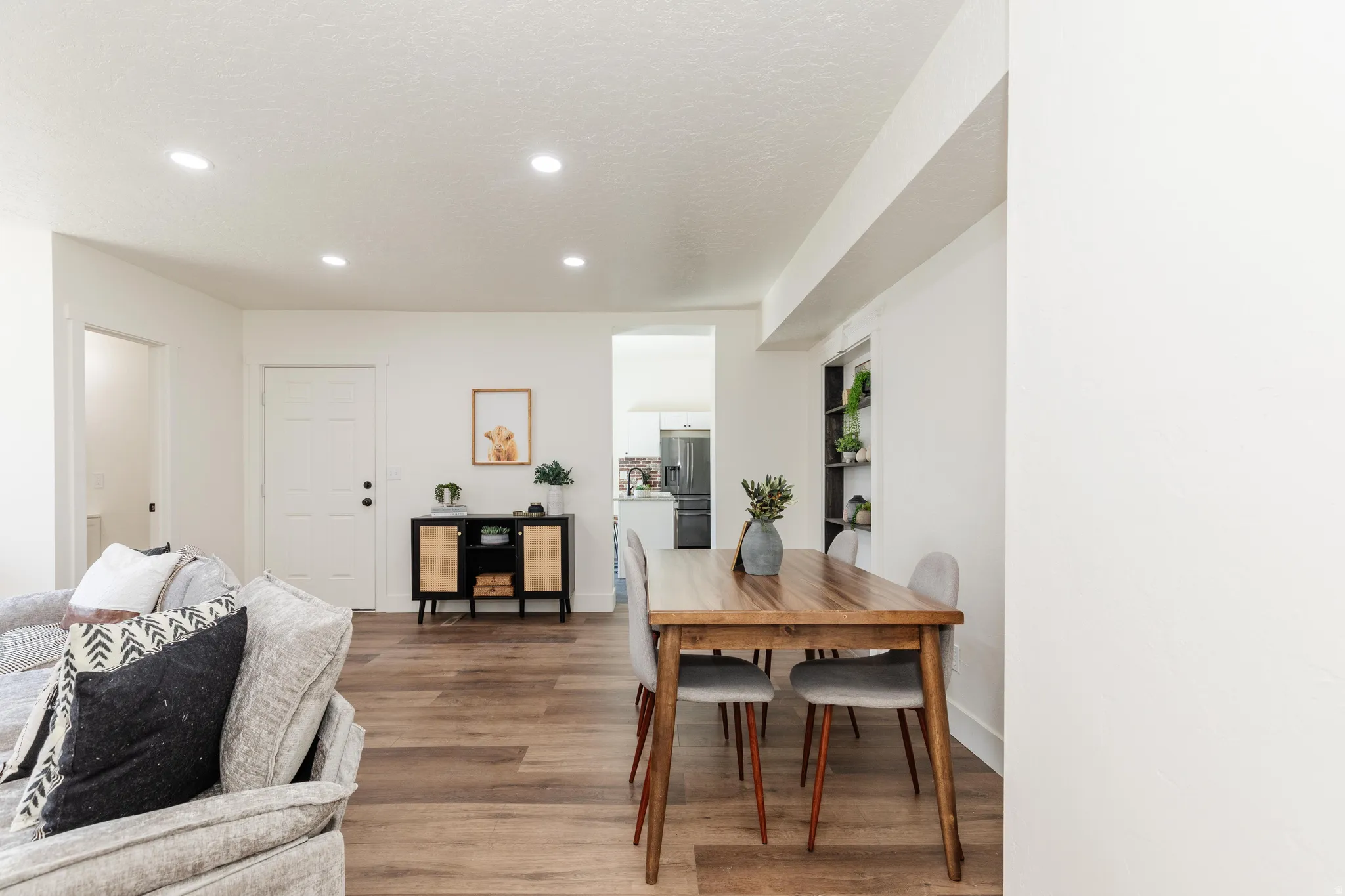 Open-concept living space featuring wood-finish flooring, recessed lighting, and white walls