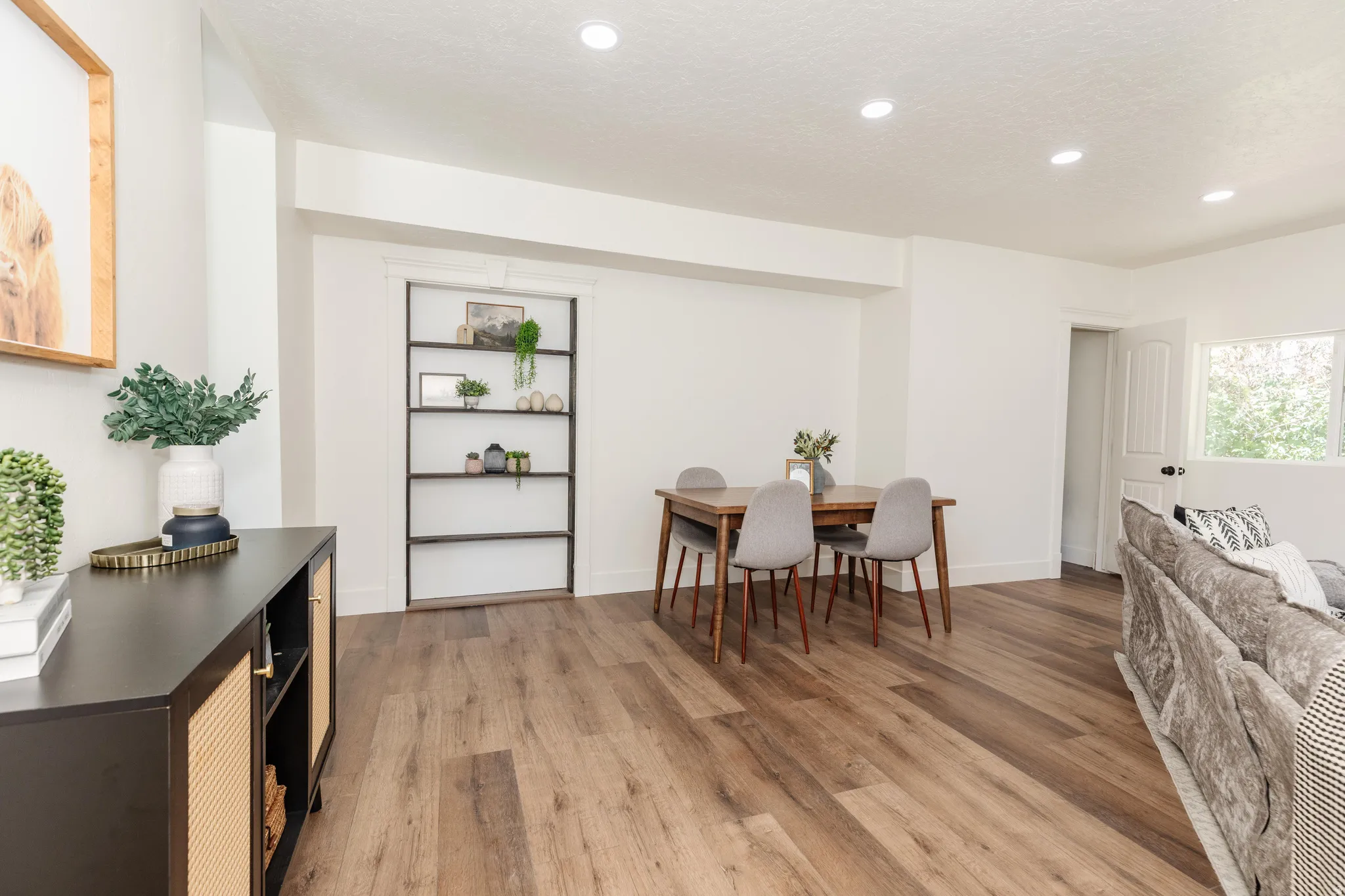 Open-concept living space with recessed lighting, wood-finish flooring, and crisp white walls