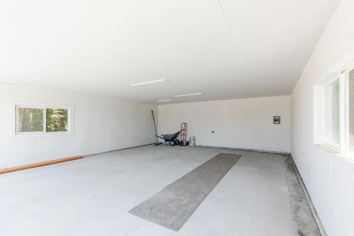 Spacious garage with multiple windows for natural light and painted concrete flooring