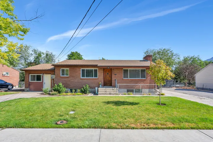 Brick exterior home with a partial front lawn