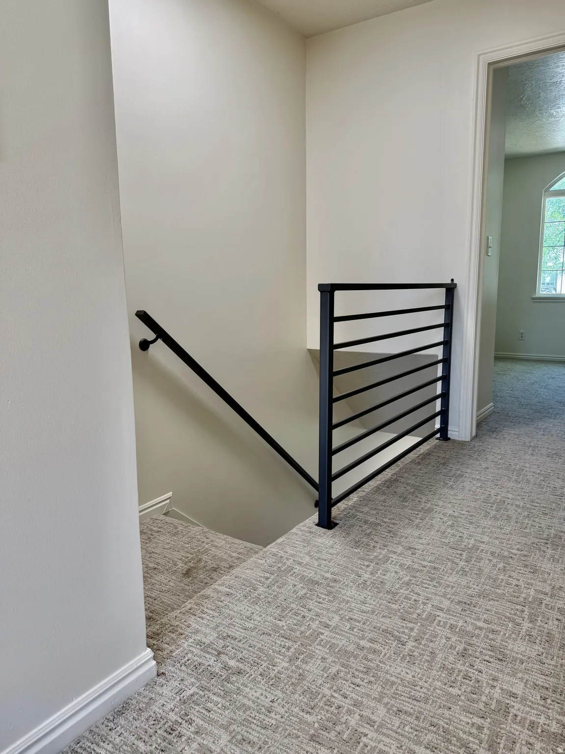 Modern black metal stair railing system with a matching handrail