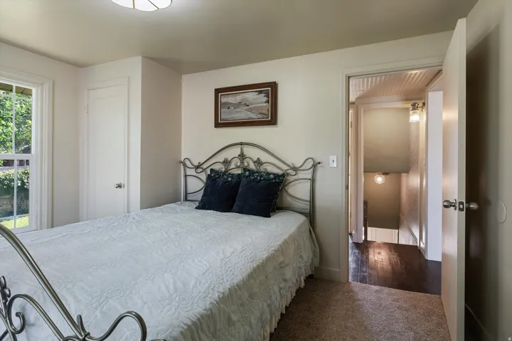 Carpeted room with a double-pane window, white trim, and a flush-mount ceiling light
