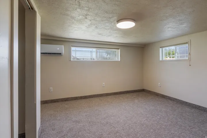 Carpeted room with neutral wall tones and a textured ceiling