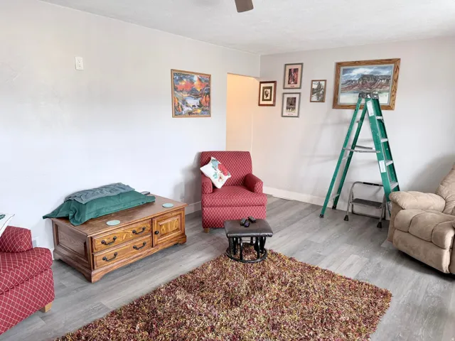 Sitting room featuring light wood-style floors, ceiling fan, and a textured ceiling