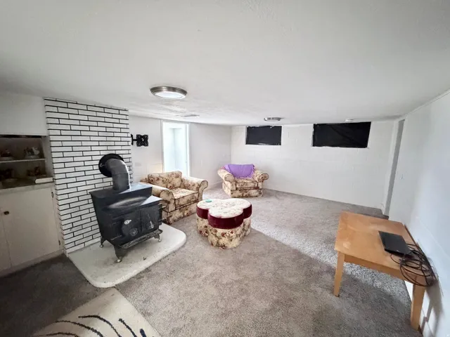 Living area featuring concrete block wall and a wood stove