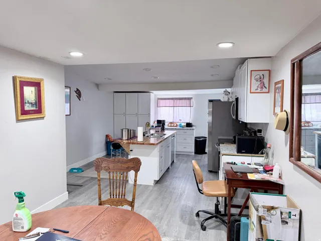 Kitchen with an office area, white cabinets, light wood-type flooring, a center island, and recessed lighting