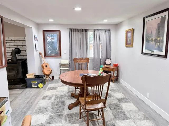 Dining area with a wood stove, wood finished floors, and recessed lighting