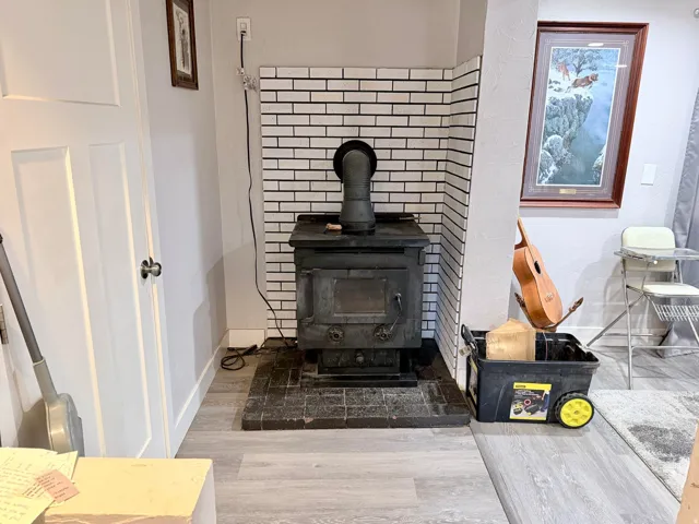 Detailed view of wood finished floors and a wood stove