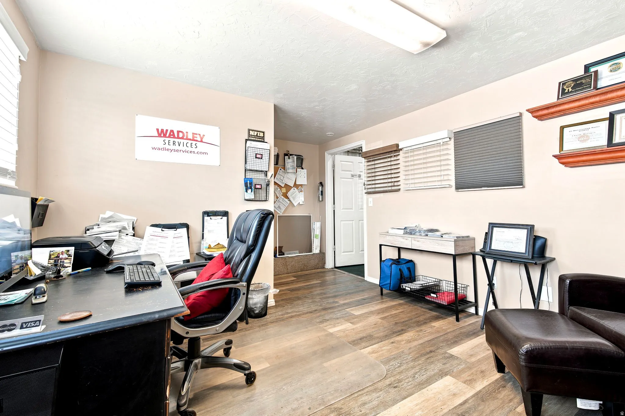 Spacious room featuring wood-finish flooring, a neutral wall color, and a white ceiling with flush-mount lighting