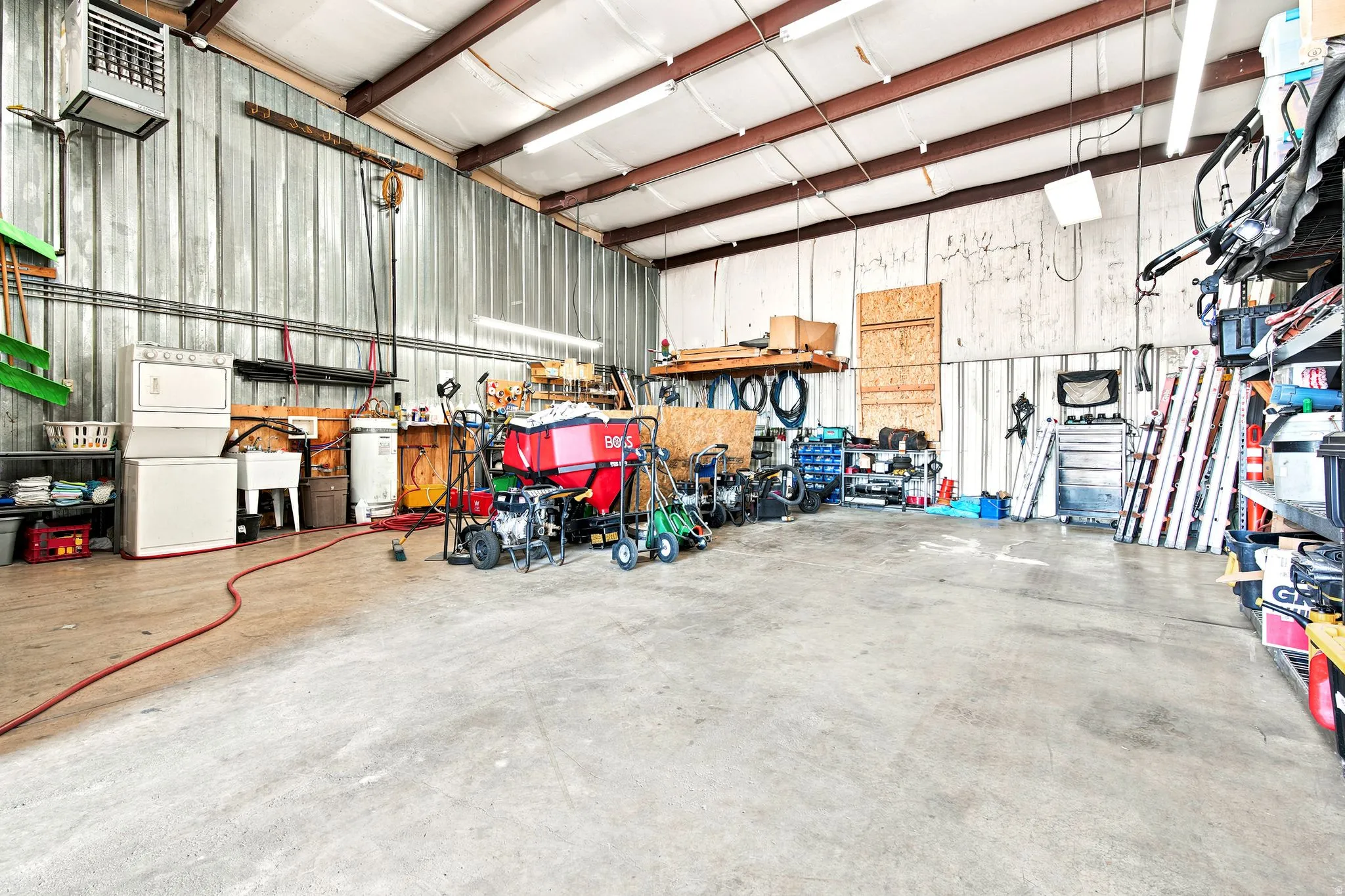 Industrial-style warehouse space featuring a concrete floor and corrugated metal walls