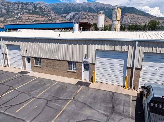 Industrial building featuring a metal roof, corrugated metal siding, and brick accents